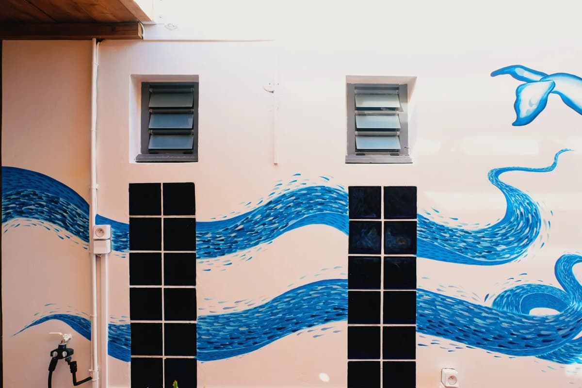 Fresque murale vagues et banc de poissons sur terrasse à La Réunion, réalisée par Lusea